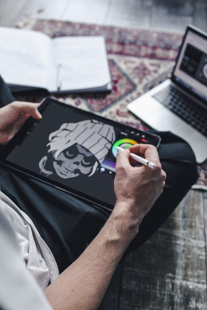 Close-up of an artist drawing on a digital tablet using a stylus pen.