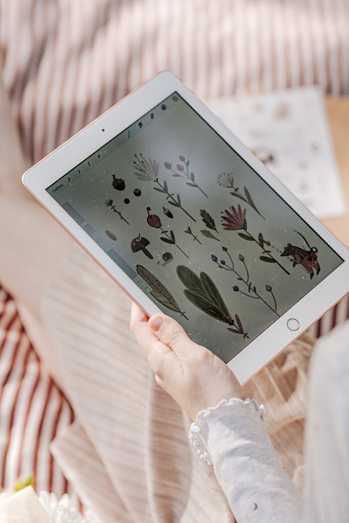 A person sketching floral illustrations on a tablet, showcasing digital art and technology integration.